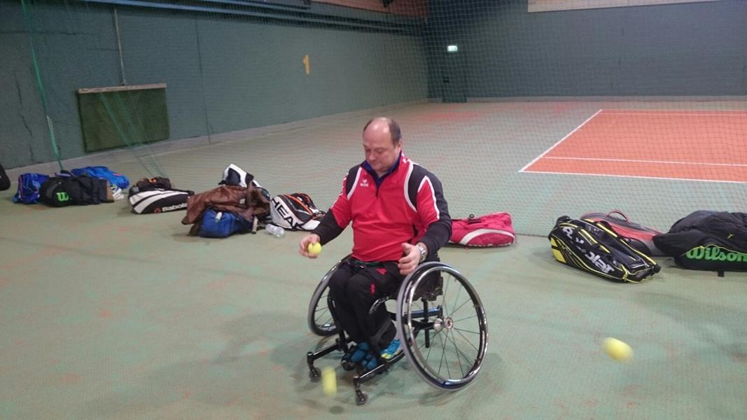 Foto von einem Rollstuhltennisspieler bei einer Koordinationsübung mit Tennisbällen