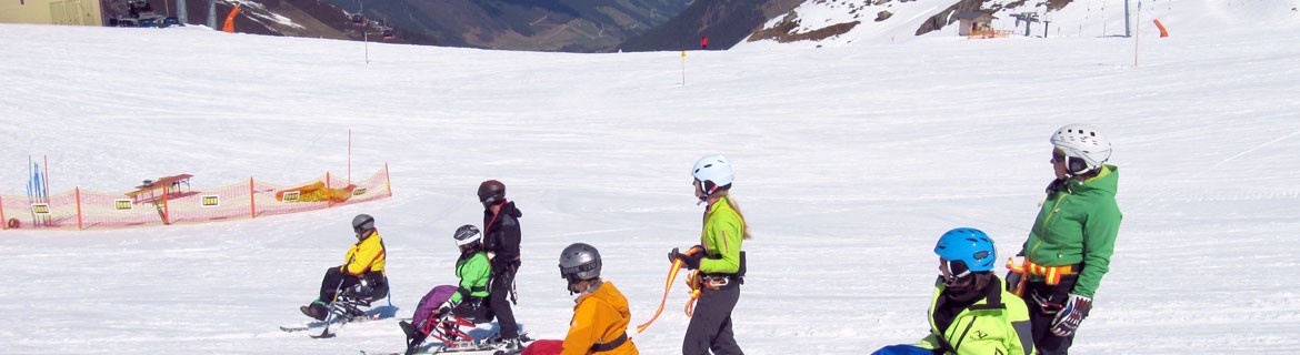 Headerbild der BSPA Innsbruck - Vier Skifahrer mit Behinderung im Monoski mit ihren Begleitfahrern