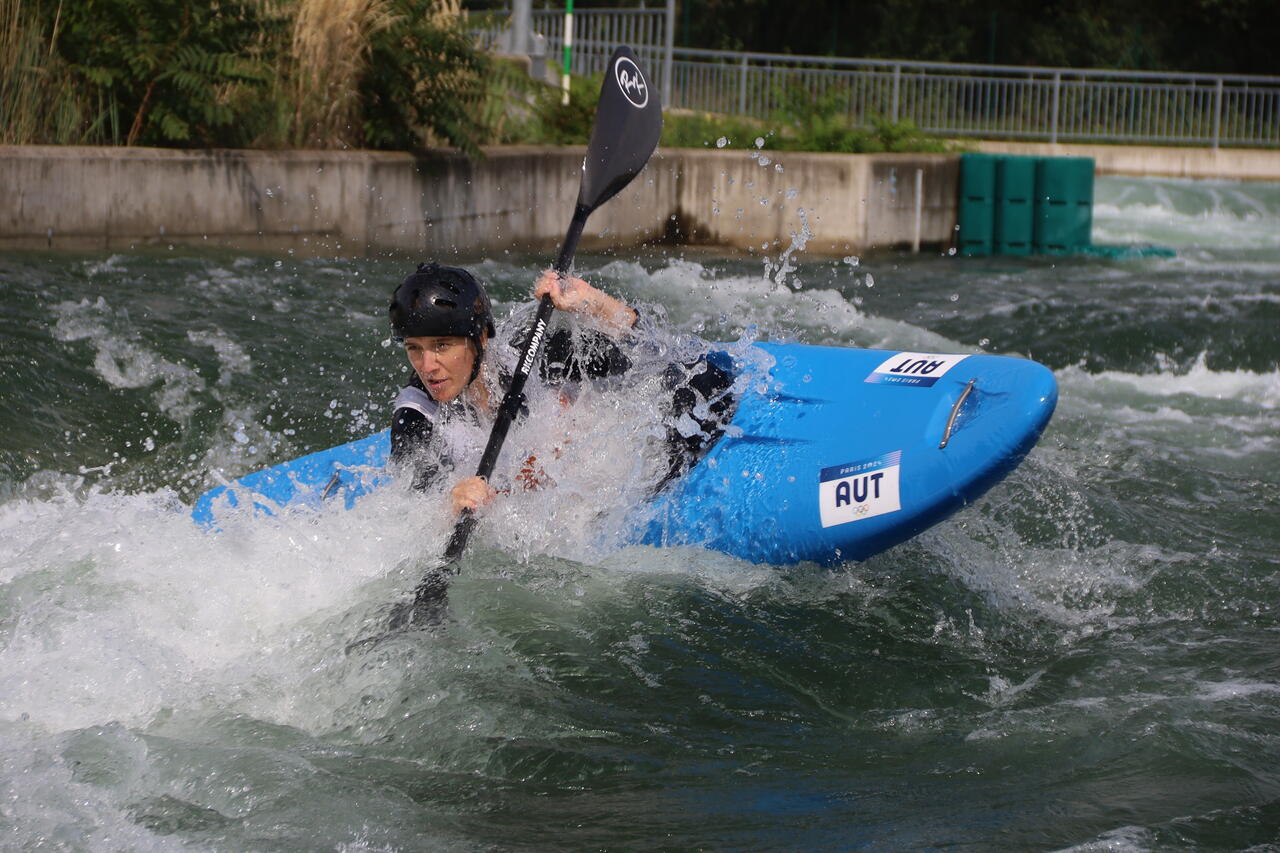 Eine Person im Kajak bei einem Manöver im Wasser