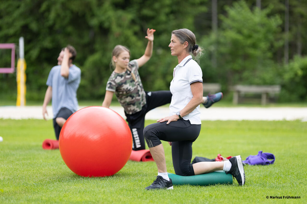 Drei Personen bei Übungen mit Gymnastikball und Aerex-Matte.